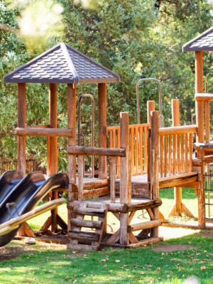 Wooden playground structure with slides